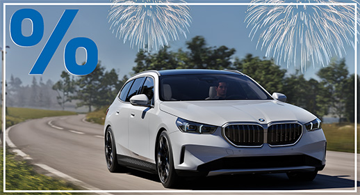 Dieses Bild zeigt eine dynamische Werbegrafik für einen weißen BMW 5er Touring, der auf einer geschwungenen Landstraße fährt. Das Fahrzeug ist in einer leichten Frontansicht dargestellt und bewegt sich durch eine sommerliche Landschaft mit grünen Bäumen und Wiesen.  Am hellen Himmel über dem Auto sind zwei große, weiße Feuerwerksblüten zu sehen, die dem Motiv eine feierliche Note verleihen. In der oberen linken Ecke prangt ein markantes, großes Prozentzeichen in Blau, das zusammen mit dem schmalen weißen Rahmen der Grafik auf eine Rabattaktion zum Jahresstart hinweist.