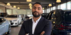 Portraitfotos eines jungen Mannes im Anzug in einem Autohaus