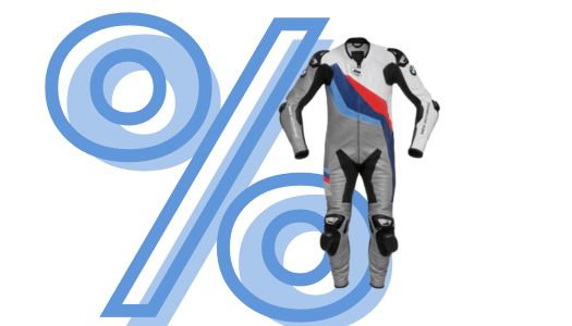 Abgebildet ist ein weiß-grauer, einteiliger Leder-Rennanzug für Motorradfahrer, der auf der Brust, den Schultern und den Beinen auffällige Grafiken in den Motorsportfarben Blau und Rot trägt. Der Anzug ist eng geschnitten und verfügt über sichtbare Protektoren oder Schleifpads an Knien und Ellenbogen, was seine Eignung für die Rennstrecke unterstreicht. Im Hintergrund befindet sich das große, hellblau stilisierte Prozentzeichen (%) vor dem weißen Hintergrund, was die Werbung für ein spezielles Angebot darstellt.