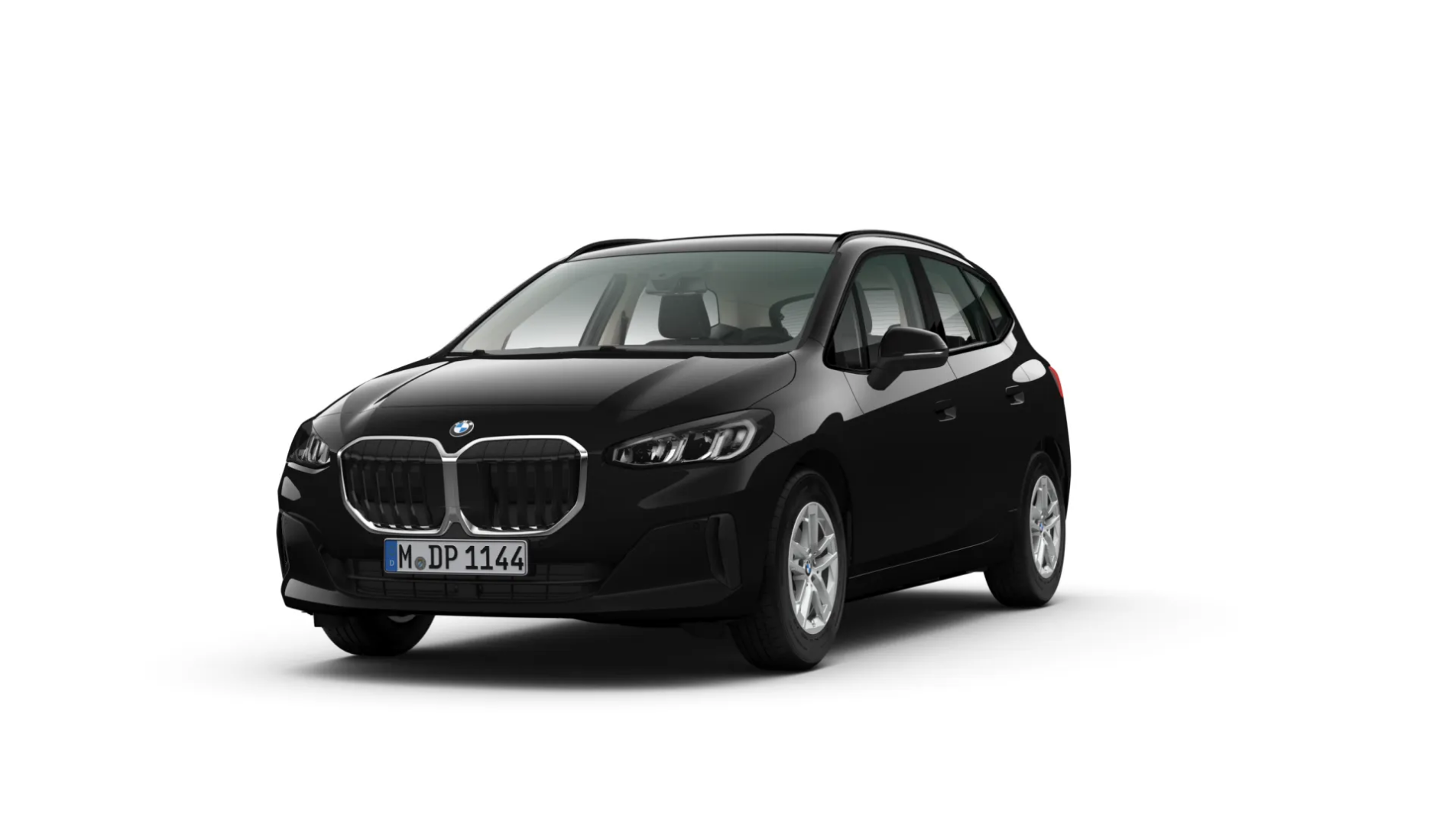 Das Bild zeigt einen schwarzen BMW 2er-Reihe Active Tourer. Das Auto steht schräg von vorne auf einem weißen, leeren Hintergrund. Es hat einen großen Kühlergrill und Dachreling. Das Kennzeichen "M DP 1144" ist auf der vorderen Stoßstange zu sehen.