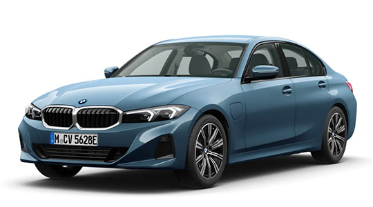 Das Bild ist eine Studioaufnahme eines BMW 3er Plug-in-Hybrid (erkennbar an der Ladeklappe am Kotflügel). Die Limousine ist in einem hellen, leicht metallischen Blauton lackiert und steht vor einem weißen Hintergrund.  Das Fahrzeug zeigt das aktuelle Design der 3er-Reihe, mit der sportlichen Niere und den modernen Scheinwerfern. Es ist mit zweifarbigen Leichtmetallfelgen ausgestattet. Das Kennzeichen lautet "M CV 5628E".