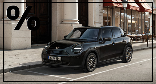 Ein klassischer, schwarzer MINI mit fünf Türen, der in einer städtischen Seitenstraße parkt. Im Hintergrund sieht man ein prachtvolles Gebäude mit hellen Säulen und ein Café mit roten Markisen. Die Szene wirkt elegant und urban. Das große schwarze Prozentzeichen in der oberen linken Ecke signalisiert ein besonderes Angebot.