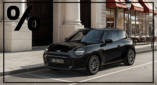 Die vollelektrische Version des 3-türigen MINI, ebenfalls in Schwarz gehalten. Er parkt in der bekannten Stadtkulisse mit dem Café im Hintergrund. Das Design ist minimalistisch und glattflächig, besonders an der Frontpartie ohne klassischen Kühlergrill. Wie bei den anderen Bildern markiert ein großes Prozentzeichen oben links die Rabatt-Aktion.