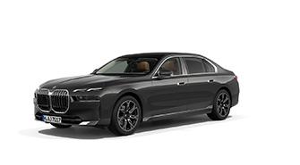 BMW 7er Limousine Das Bild zeigt einen dunkelgrauen BMW i7, eine luxuriöse, viertürige Limousine. Das Auto steht schräg von vorne auf einem weißen, leeren Hintergrund. Das Kennzeichen "M HA 5257" ist auf der vorderen Stoßstange zu sehen.