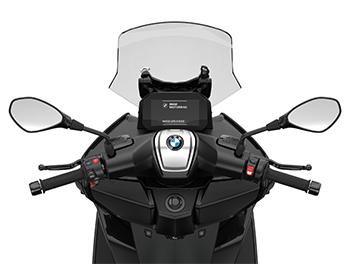 Die Cockpit-Ansicht zeigt die Arbeitsplatz-Ergonomie des GT-Modells. Auch hier steht das Connectivity-Display im Fokus, das beim Starten den „BMW Motorrad“-Schriftzug anzeigt. Auffällig im Vergleich zum X-Modell ist die breitere Verkleidung rund um den Lenker, die einen besseren Wetterschutz für die Hände und den Oberkörper bietet. Die silberne Abdeckung in der Mitte des Lenkers mit dem BMW-Emblem wirkt edel und rundet das hochwertige Erscheinungsbild der Armaturen ab.