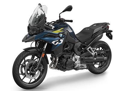  Auf dem Bild ist eine BMW F 800 GS abgebildet, ein mittelgroßes, dunkelblaues und gelbes Motorrad, das auf einem weißen Hintergrund steht.  Das Motorrad ist in einem hellen, sonnigen Licht und steht seitlich zur Kamera. Es ist sauber und glänzt, als wäre es brandneu.