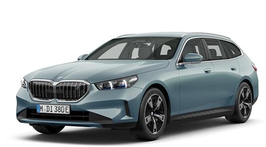 Ein frontaler Blick auf einen mittelblauen BMW i5 Touring Kombi, der leicht nach rechts gedreht ist und dessen Kennzeichen "M DI 380 E" lautet. Das Auto hat helle Fenster, und die Felgen sind silber mit schwarzen Akzenten. Der Hintergrund ist reinweiß.