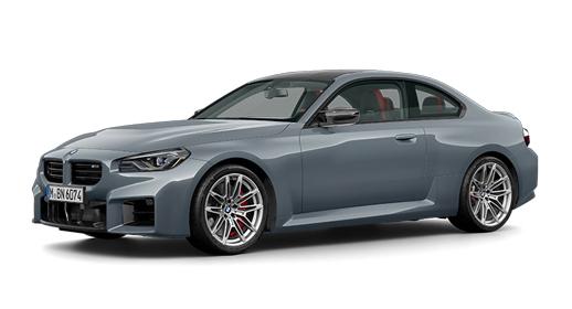 Ein sportlicher, zweitüriger BMW M2 Coupé in mattem Grau steht schräg von vorne auf einem weißen Hintergrund. Man sieht die markanten Lufteinlässe und den Nierenkühlergrill an der Front, die eleganten Linien der Karosserie und die silbernen Felgen mit roten Bremssätteln. Durch die Fenster sind rote Akzente im Innenraum erkennbar.