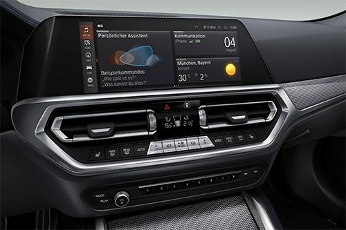 „Innenraum eines BMW mit zentralem Display und Bedienelementen für Klimaanlage und Lüftung.“