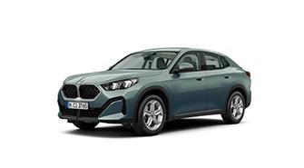 Das Bild zeigt ein graugrünes BMW iX2 Coupé. Es ist ein viertüriges SUV mit einer abfallenden Dachlinie im Coupé-Stil. Das Auto steht schräg von vorne auf einem weißen, leeren Hintergrund. Das Kennzeichen "M CI 3956" ist auf der vorderen Stoßstange zu sehen