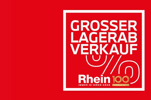 Das Bild ist eine Werbegrafik mit einem leuchtend roten Hintergrund. Ein weiß eingerahmtes Quadrat auf der rechten Seite enthält den Text „GROSSER LAGERAB VERKAUF“ in weißen Großbuchstaben. Darunter befinden sich weiße, stilisierte Linien (vermutlich Räder oder ein Rabattsymbol). Im unteren Bereich des Quadrats steht der Name „Rhein 100“ in weißer und roter Schrift, wobei eine kleine gold-rote Plakette mit der Aufschrift „DAS GUTE BRAUCHT KONTROLLE“ integriert ist. Darunter in kleiner weißer Schrift der Slogan „IMMER IN IHRER NÄHE“. Das Design ist auffällig und werblich.