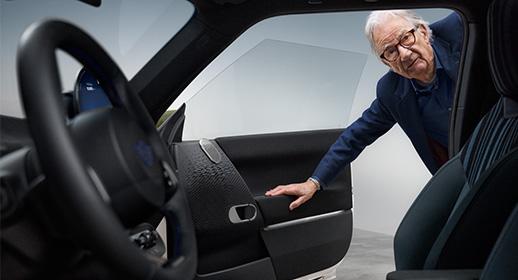 Blick in den Innenraum der MINI Paul Smith Edition: Modedesigner Sir Paul Smith begutachtet die exklusive Ausstattung und das Interieur-Design durch die geöffnete Fahrertür eines MINI Cooper.