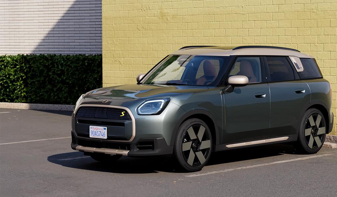 Das dritte Bild zeigt den MINI Countryman Electric, das größte Modell der neuen MINI-Familie, in einer eleganten dunkelgrünen Metallic-Lackierung mit einem kontrastierenden beigefarbenen Dach. Als vielseitiger Crossover präsentiert er sich deutlich robuster und geräumiger als seine Geschwister, was sich in einer Länge von ca. 4,44 Metern und einem Kofferraumvolumen von bis zu 1.450 Litern widerspiegelt. Mit einer Leistung von bis zu 313 PS im Allradmodell und einer elektrischen Reichweite von bis zu 462 Kilometern kombiniert er Abenteuerlust mit moderner Effizienz. Die Szenerie vor einer hellen Backsteinwand unterstreicht dabei das klare, reduzierte Design und die markante Präsenz dieses vollelektrischen SUV.