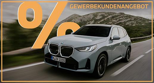 Das Bild zeigt einen hellgrauen BMW X3 auf einer Straße, die durch eine bergige Landschaft führt. Oben im Bild steht der Text „GEWERBEKUNDENANGEBOT“ und links ist ein großes, oranges Prozentsymbol zu sehen. Ein orangefarbener Rahmen umgibt das gesamte Bild.