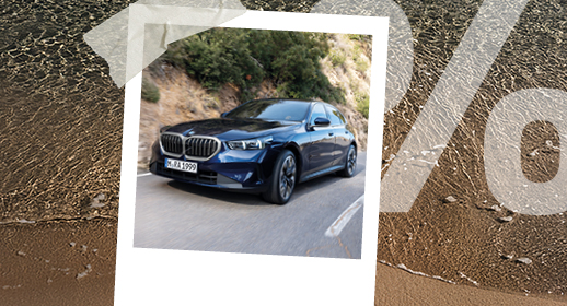 Ein Polaroid-Foto auf Strand-Hintergrund zeigt einen dunkelblauen BMW 5er auf einer Bergstraße. Rechts ist wieder das große, transparente Prozentzeichen (%) zu sehen.